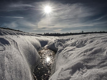 Vinter og sol med smeltende hull i snøen