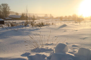 Landlig vinterlandskap opplyst av solen. 