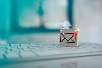 Liten trekloss med konvolutt og varslingssymbol for sjekk e-post, på tastatur.